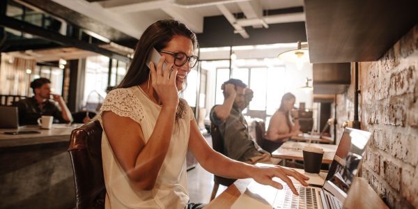 Casual businesswoman working at startup office Young woman sitting at office and using mobile phone. Casual businesswoman working at startup office.